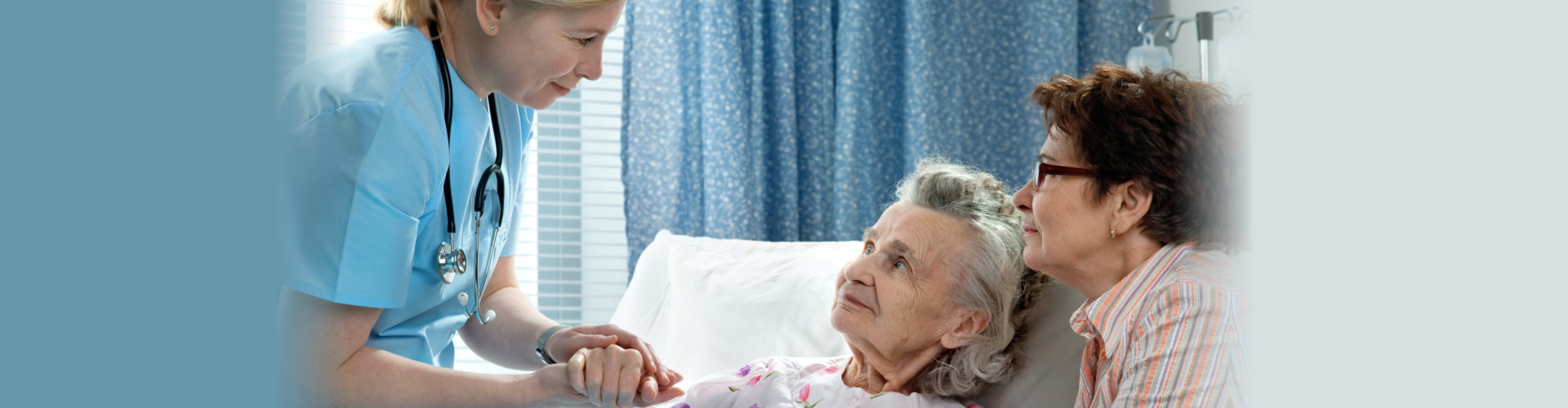 nurse attending to elderly woman in bed